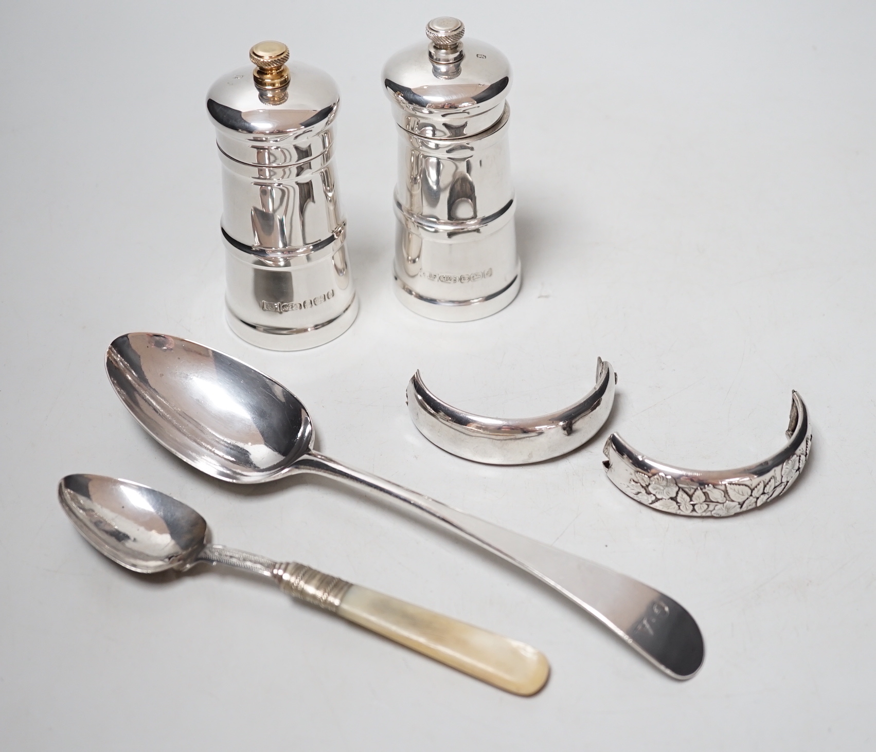 A modern pair silver mounted salt and pepper grinders, 10.6cm, a Georgian silver table spoon, A Victorian mother of pearl handled spoon and a damaged silver bangle.